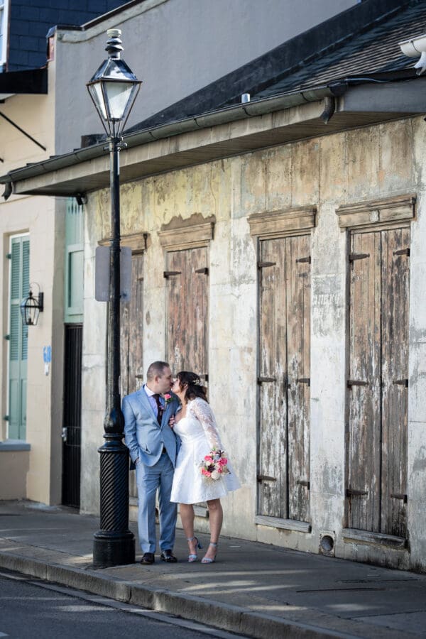 Bride and groom kiss by lamp post in the French Quarter