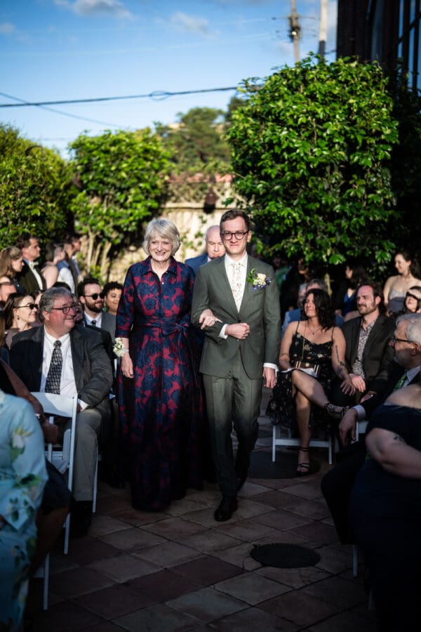 Groom and mother walk up the aisle