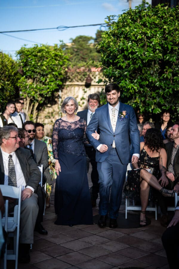 Groom and mother walk up the aisle