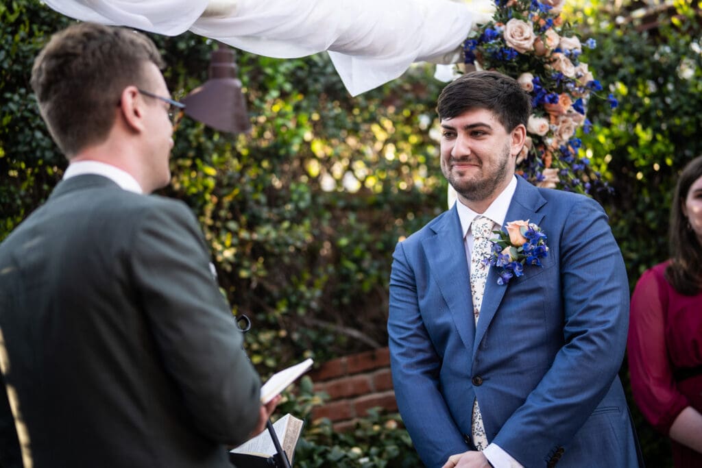 Groom smiles during wedding ceremony