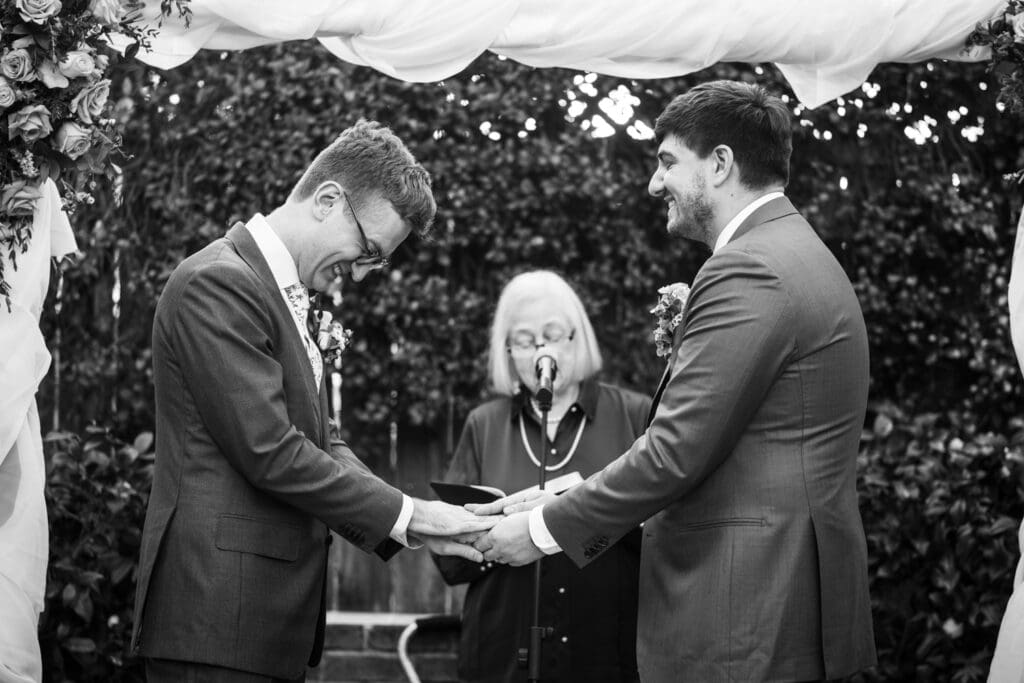 Grooms laugh during wedding ceremony