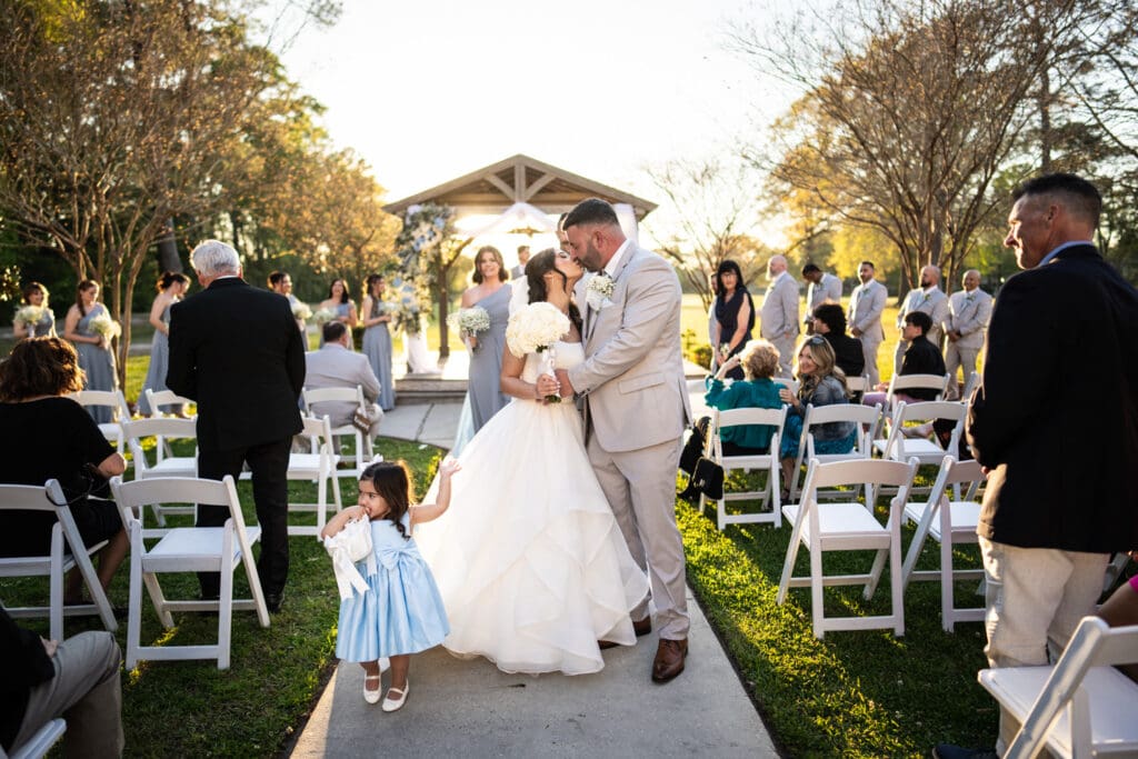 Bride and groom kiss in the aisle after wedding ceremony at the Sadie Jane