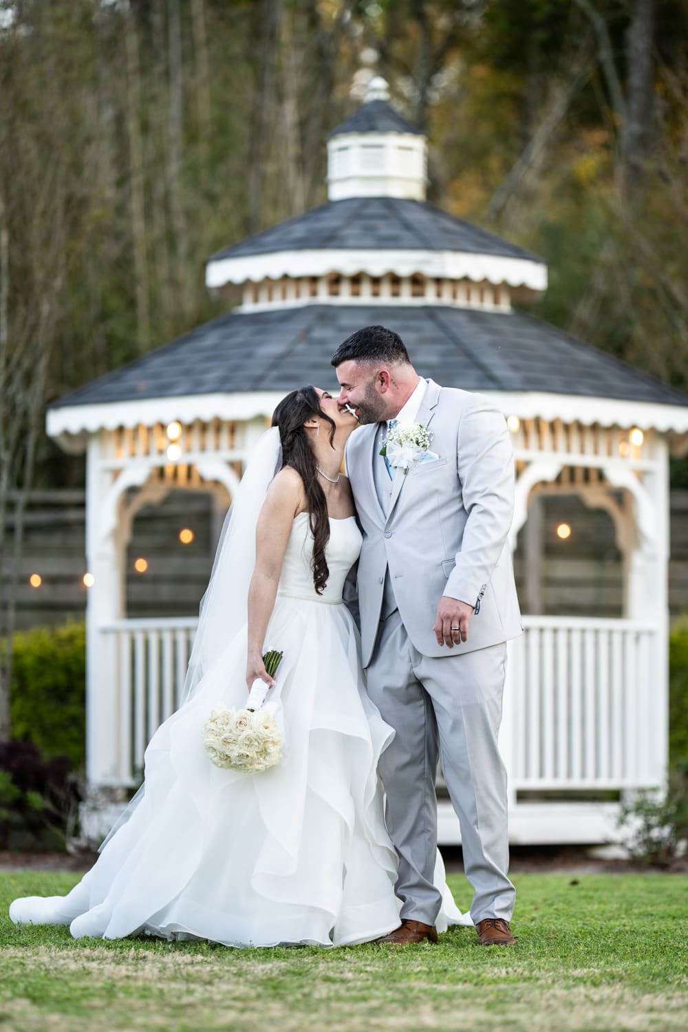 Bride and groom kissing in front of gazebo at the Sadie Jane in Slidell