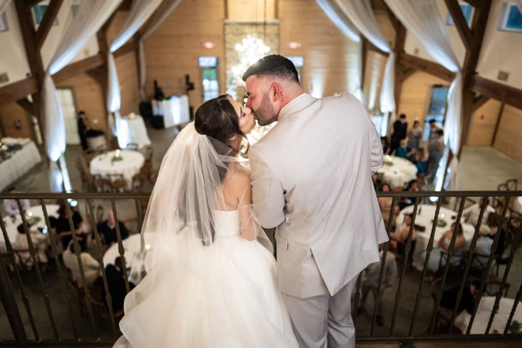 Bride and groom kiss on Sadie Jane balcony
