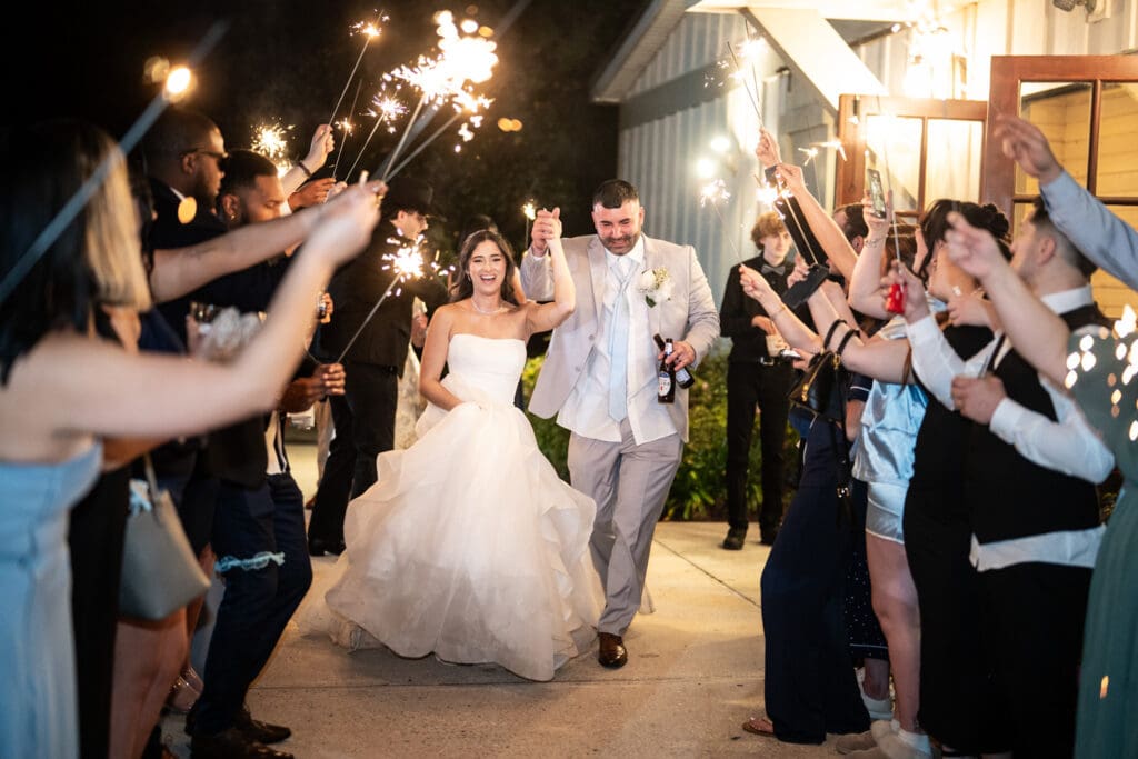 Bride and groom run through sparklers at the Sadie Jane