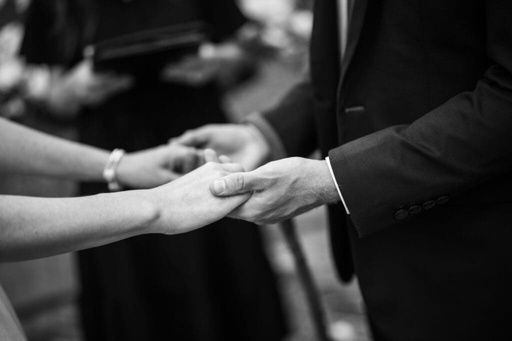 Close-up of bride and groom holding hands