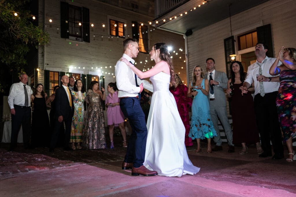 Bride and groom dancing as guests look on