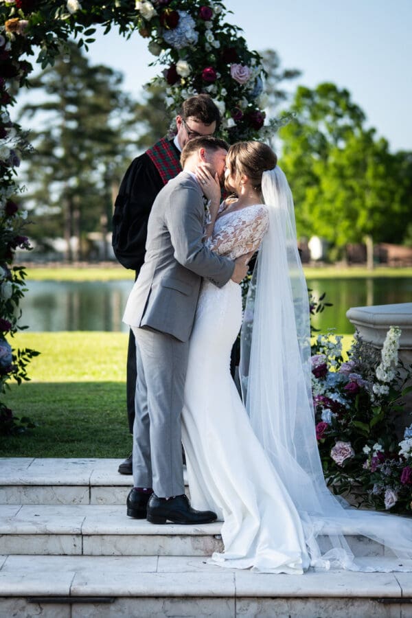 Bride and groom kiss at conclusion of wedding ceremony