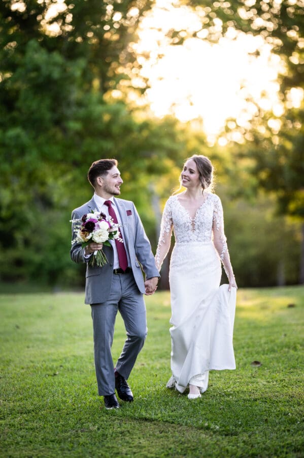 Bride and groom walk along grass at Ponchatoula 22 Estate wedding