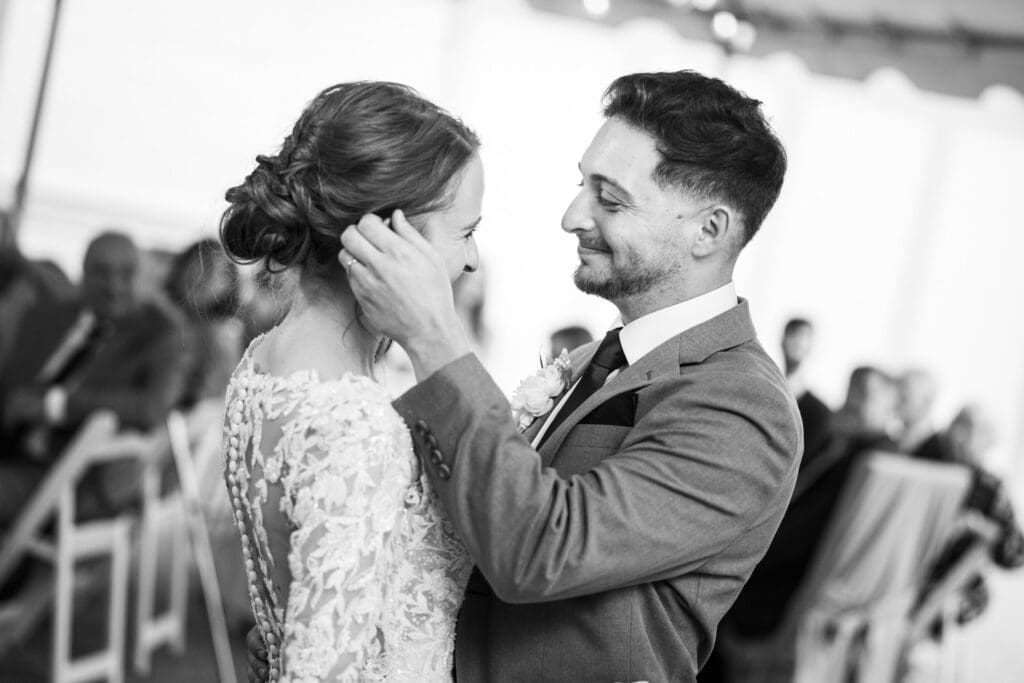 Groom caresses bride's face as they have first dance