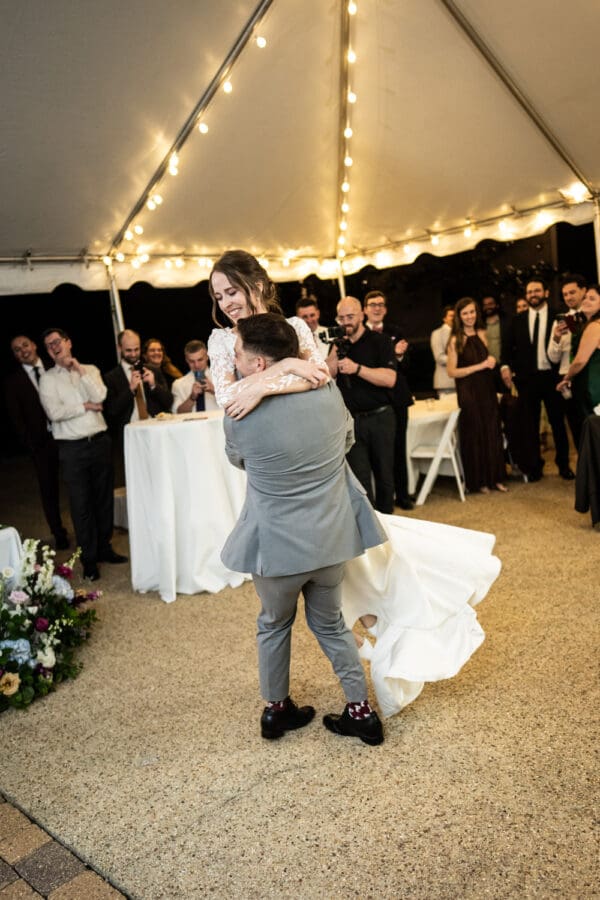 Groom lifts and twirls bride during wedding reception