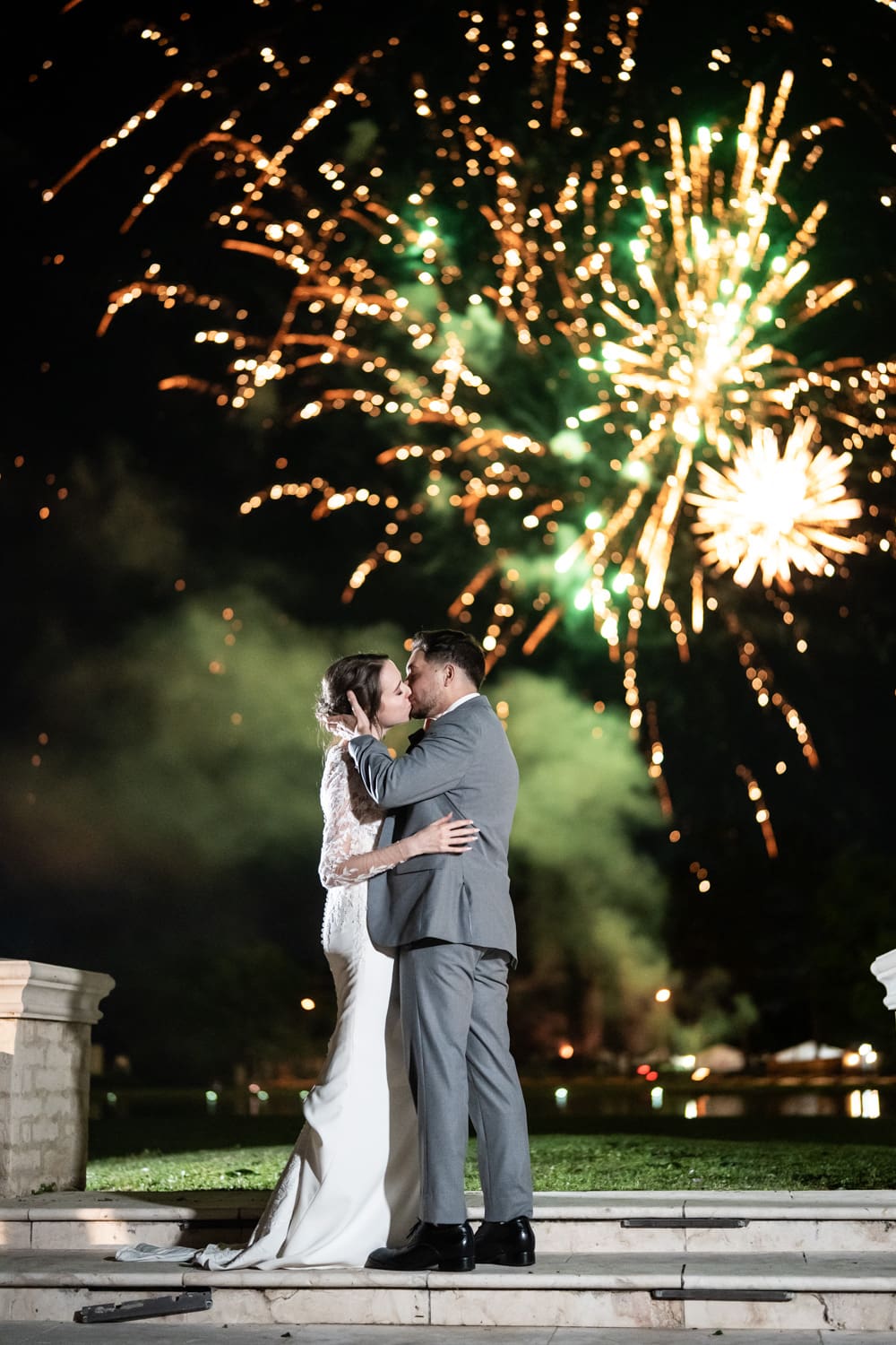 Bride and groom kiss with fireworks in the background at Ponchatoula 22 estate
