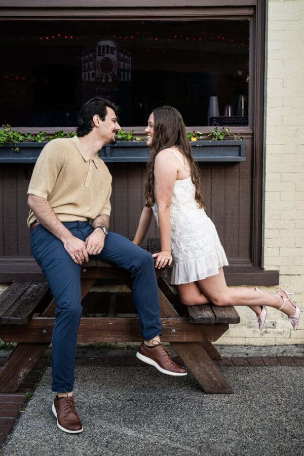 Couple on wooden bench in front of bar in Olde Town Slidell