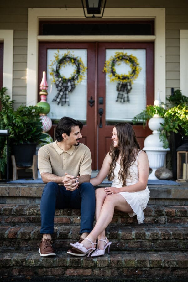 Couple sitting on steps of home in Olde Town Slidell