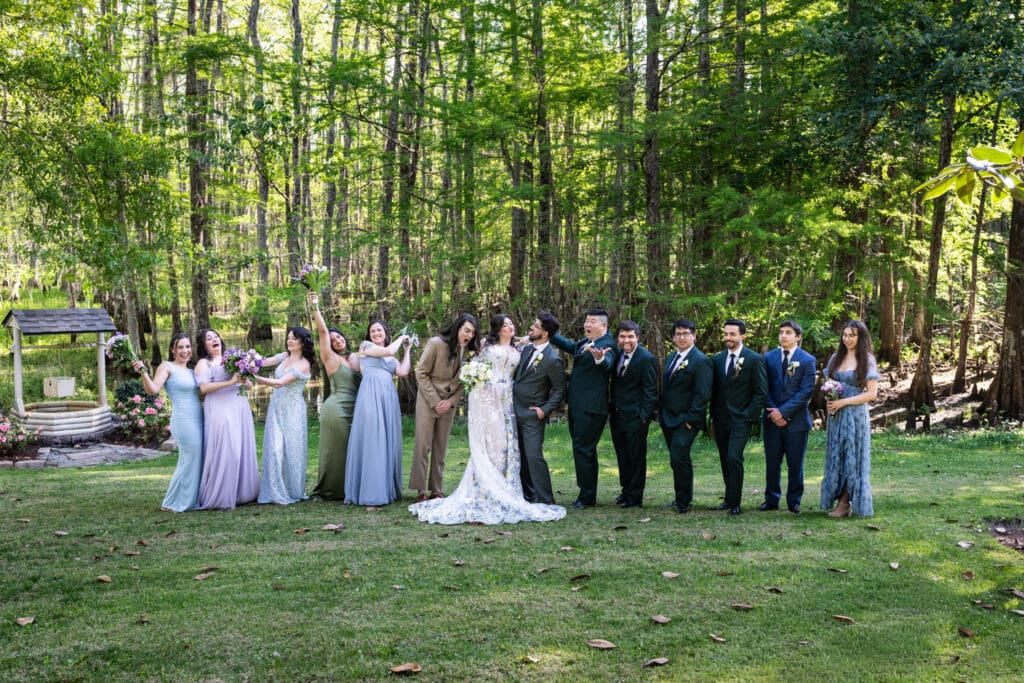 Bride and groom do silly photo with wedding party