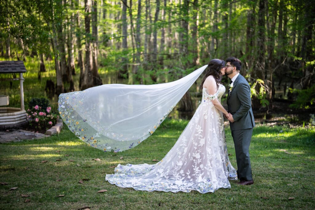 Bride and groom kiss with swamp in the backgtround