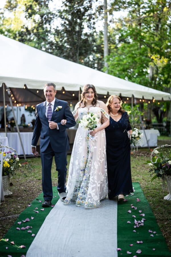 Bride and parents walk up the aisle