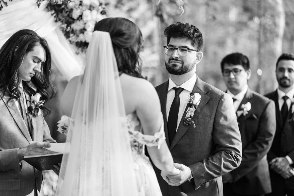 Groom smiles at bride during vows