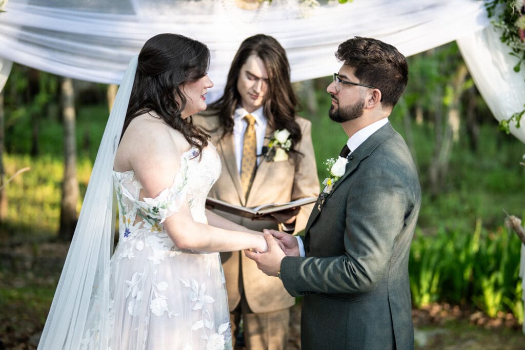 Bride and groom hold hands during vows