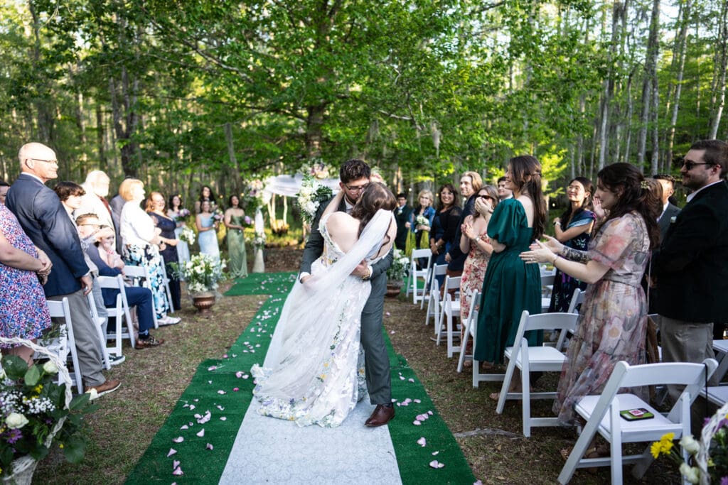 Groom dips bride in aisle
