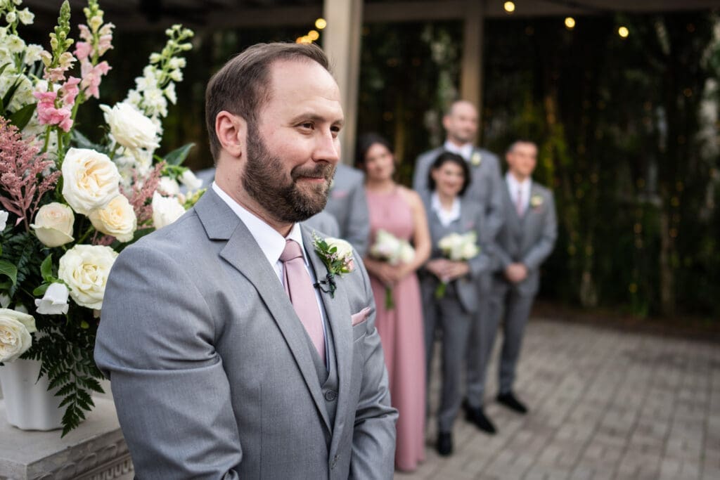 Groom watches bride walk up the aisle