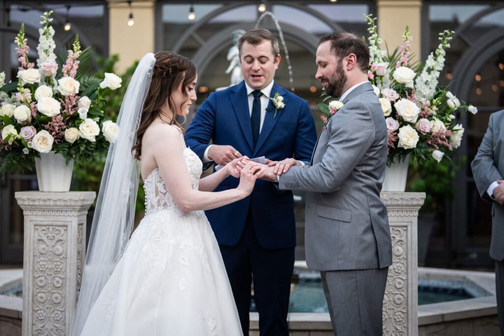 Bride places ring on the groom's finger