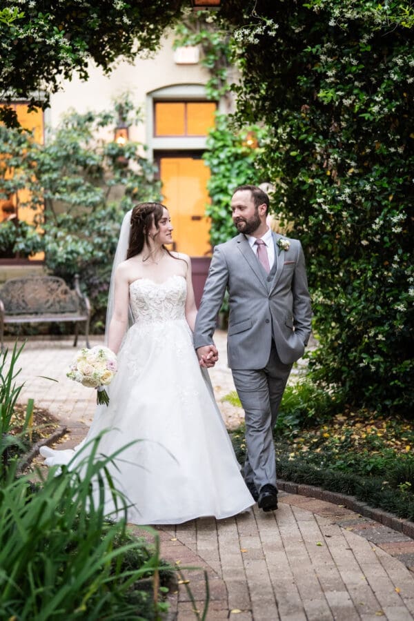 Bride and groom walk on pathway at the Southern Hotel in Covington