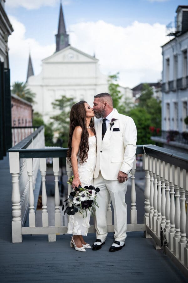Bride and groom kissing on balcony