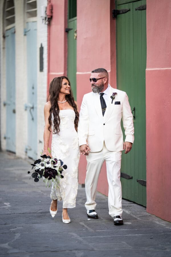 Bride and groom walking through Pirate's Alley in the French Quarter