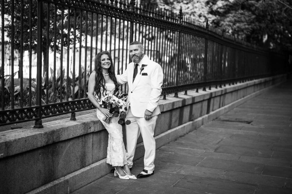 Bride and groom by Jackson Square wrought iron fence