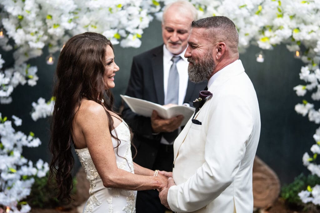 Bride and groom smile at each other during wedding ceremony