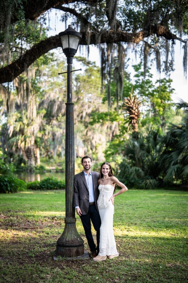 Couple standing by lamp post in park