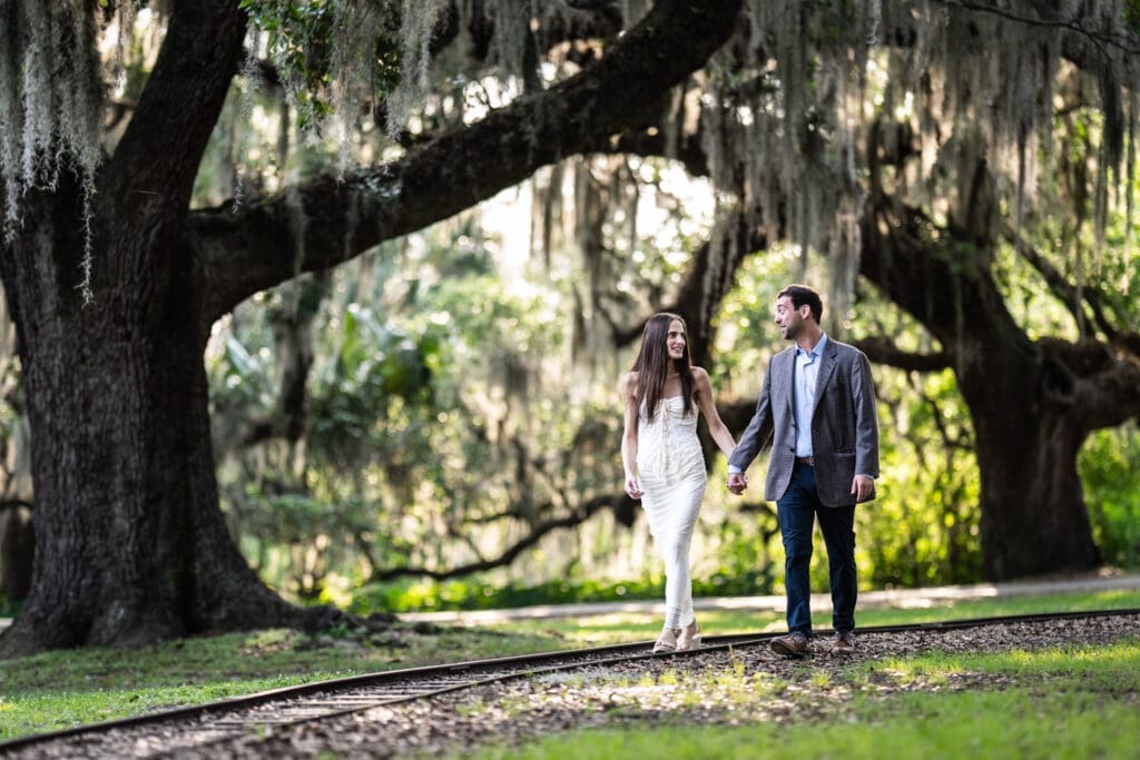 Couple walking along railroad tracks in park