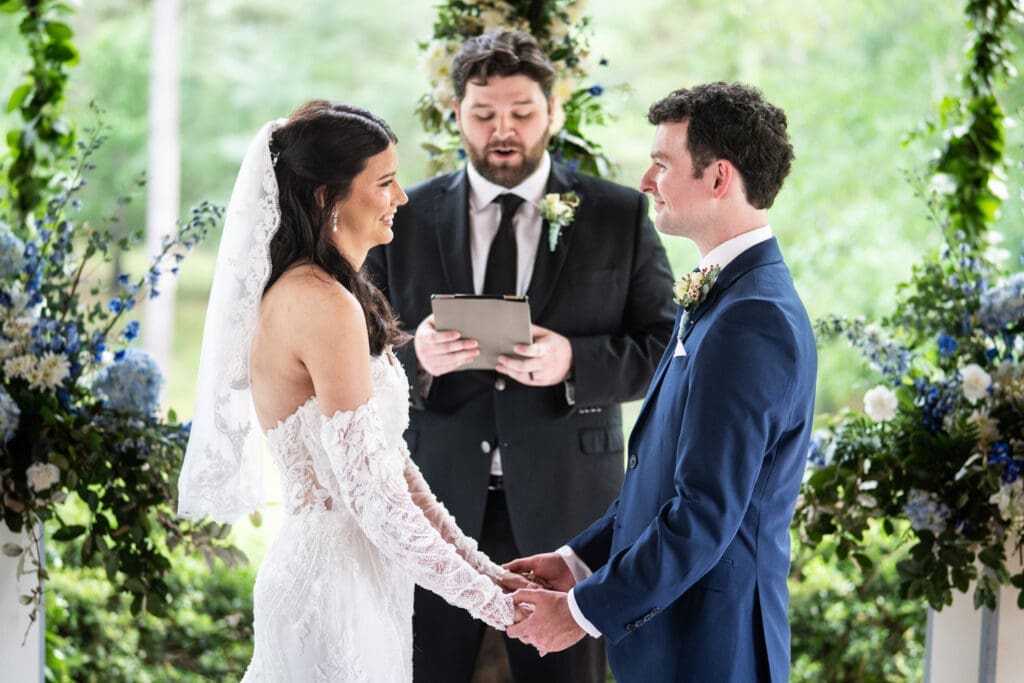 Bride and groom smile at each other during wedding ceremony
