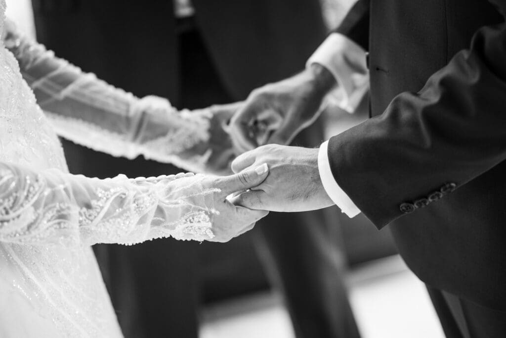 Close-up of bride and groom holding hands