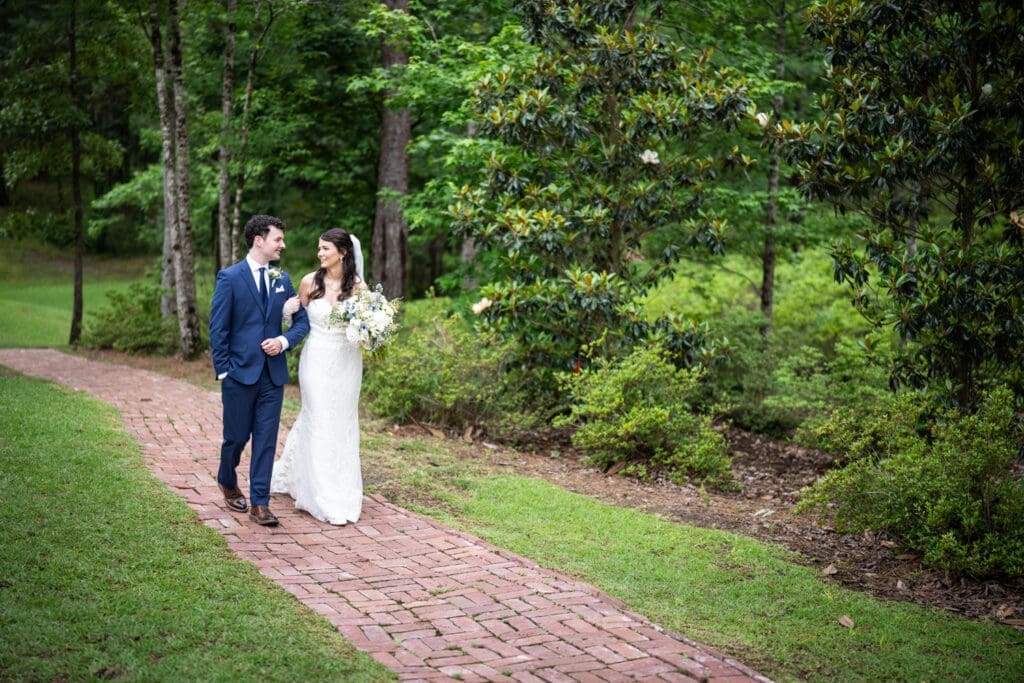 Bride and groom walking down brick-paved pathway