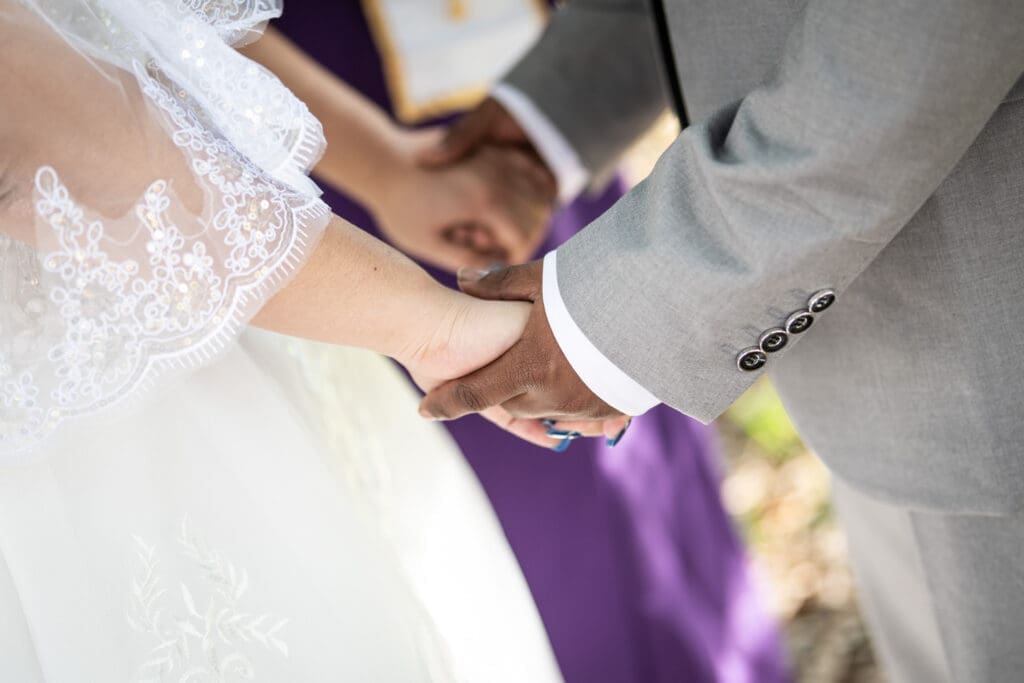 Couple holding hands during wedding ceremony