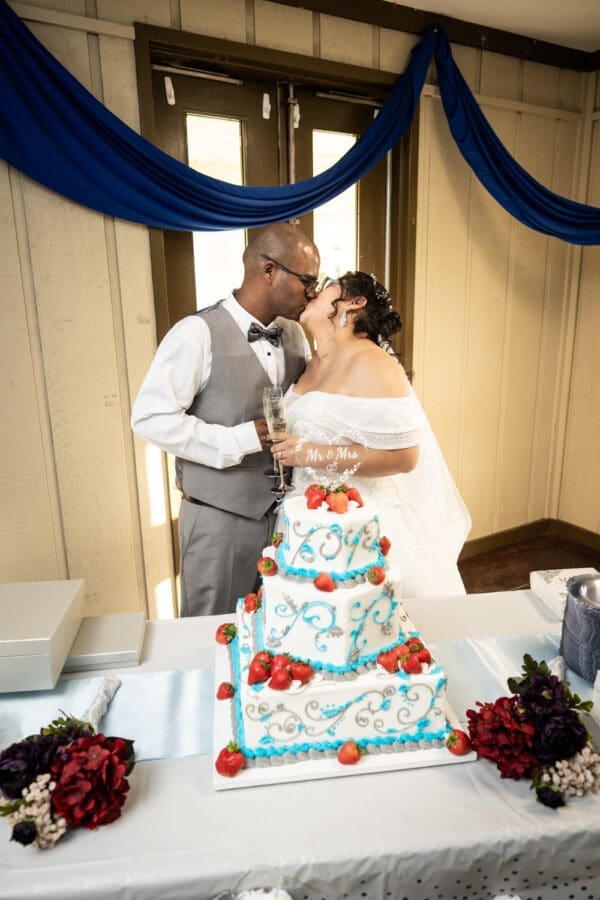 Couple kisses as they cut their wedding cake