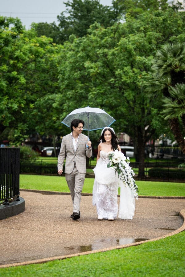 Bride walking with escort holding an umbrella