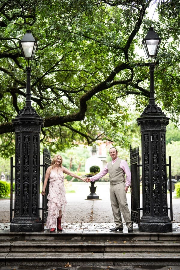 Couple holding hands at gates to Jackson Square