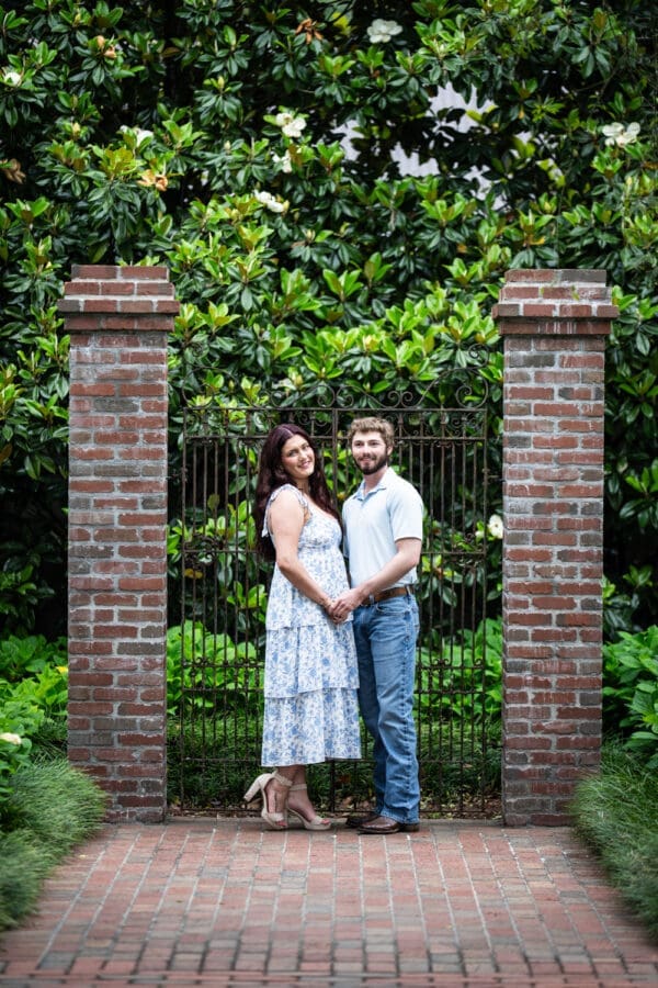 Couple standing in front of old gate at Oak Alley