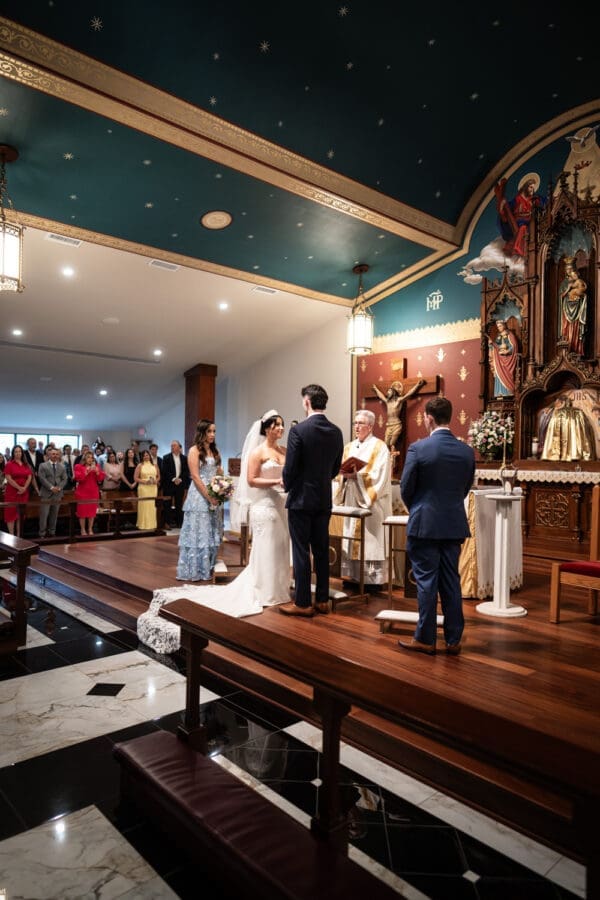 Bride and groom standing on altar holding hands