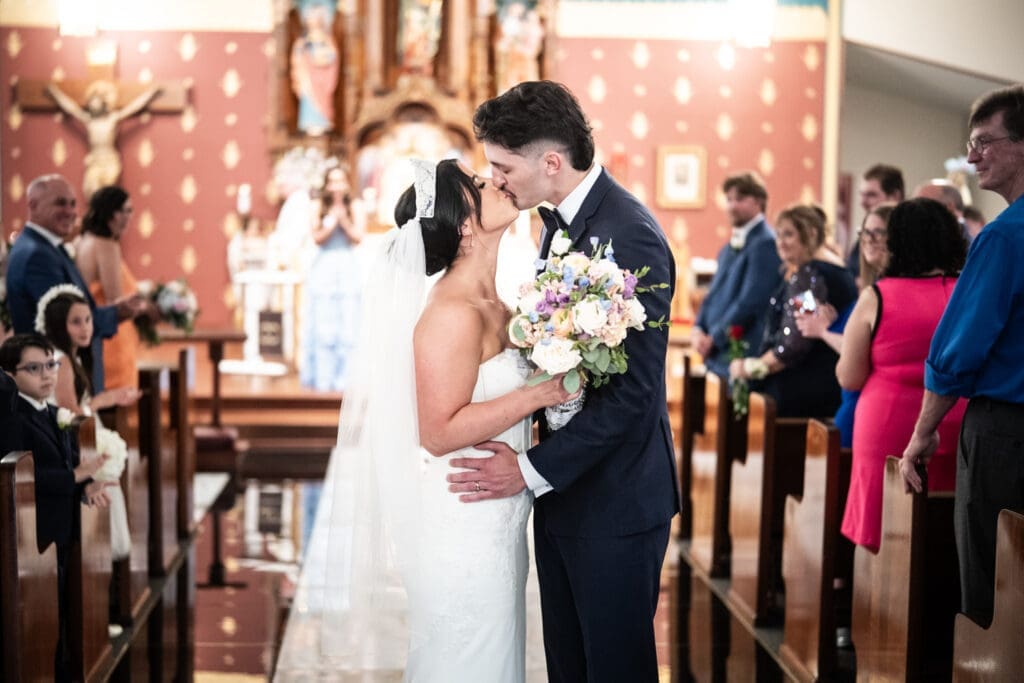 Bride and groom kiss at conclusion of wedding ceremony