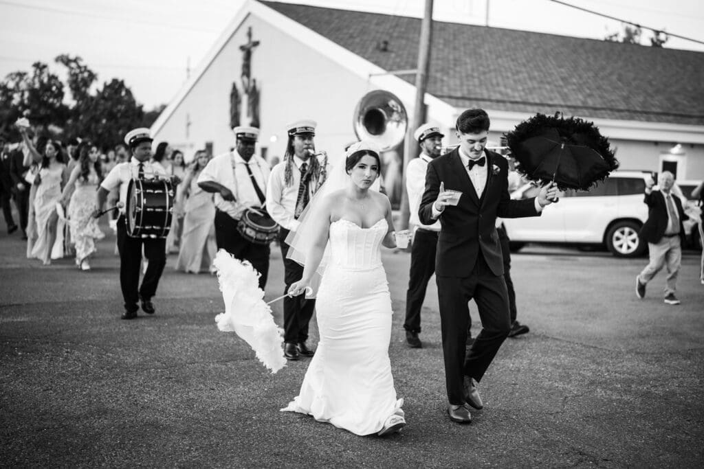 Bride and groom walking in front of brass band