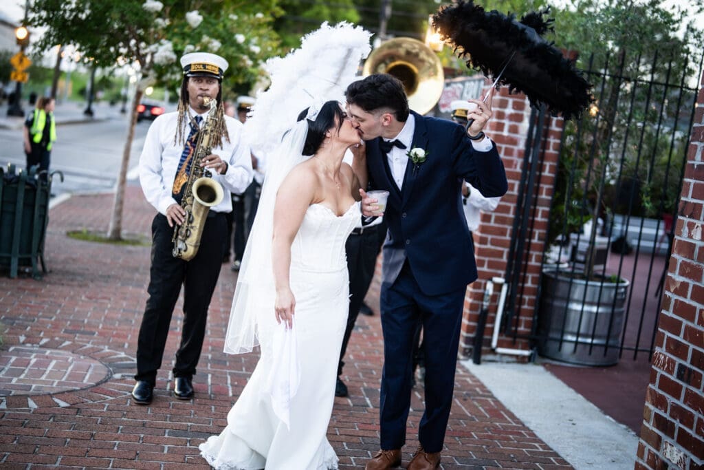 Bride and groom kiss in front of brass band