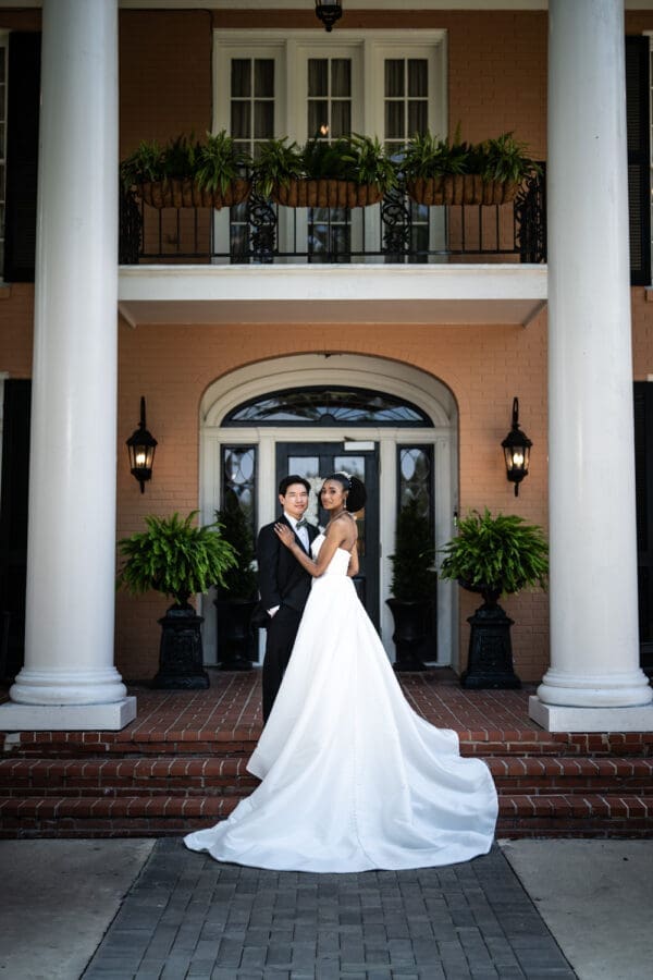 Bride and groom on front porch of Southern Oaks