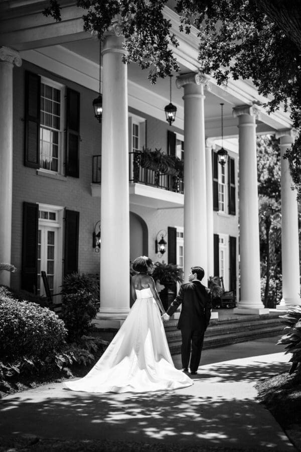 Bride and groom walking along driveway