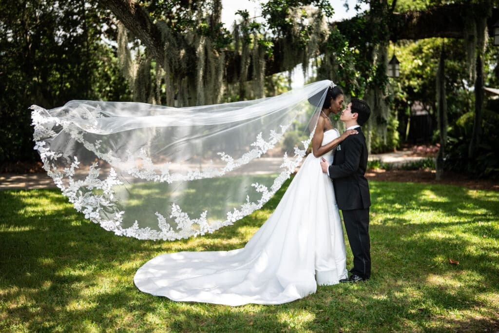 Bride and groom with veil blowing in the wind
