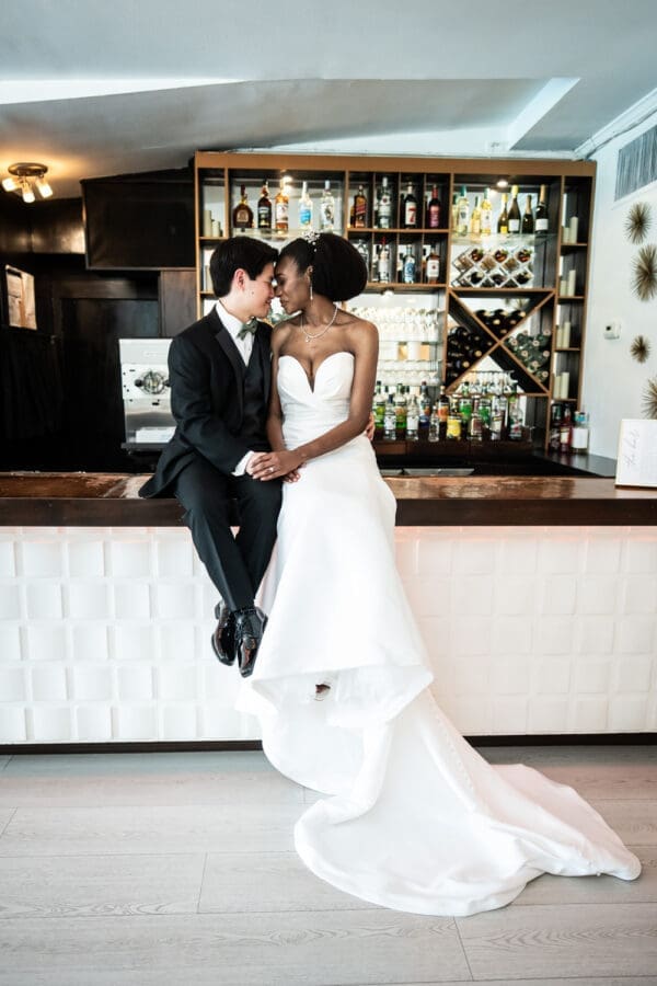 Bride and groom sitting on bar at Southern Oaks