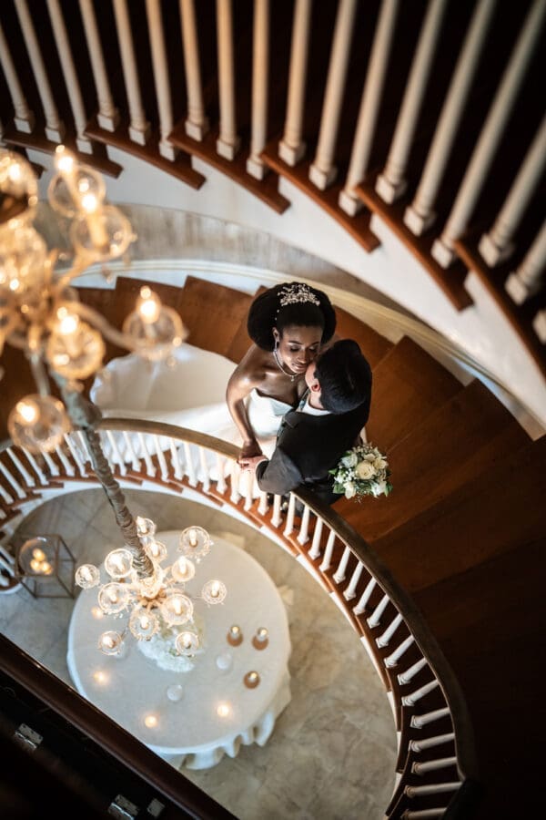 Bride and groom embracing on spiral staircase at Southern Oaks